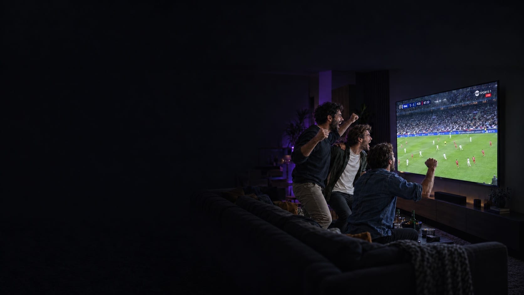 Friends celebrating a goal while watching live football on VokTV